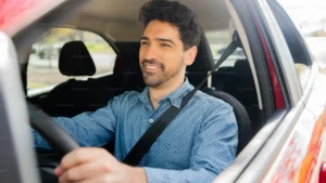 Hombre sonriendo mientras conduce un coche.