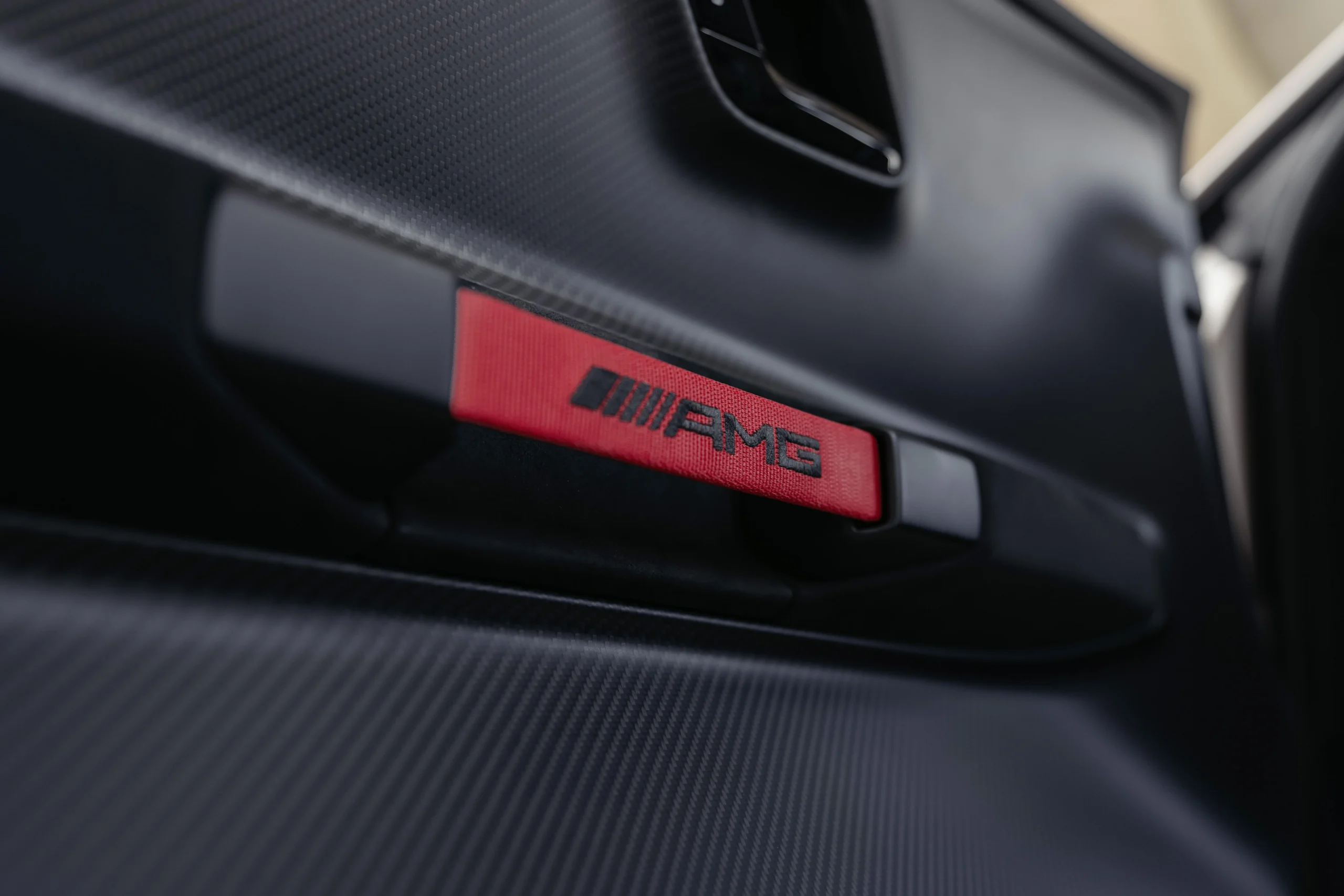 Mercedes-AMG CLE 646 Spezialanfertigung: Detalle del interior de un vehículo con emblema AMG.