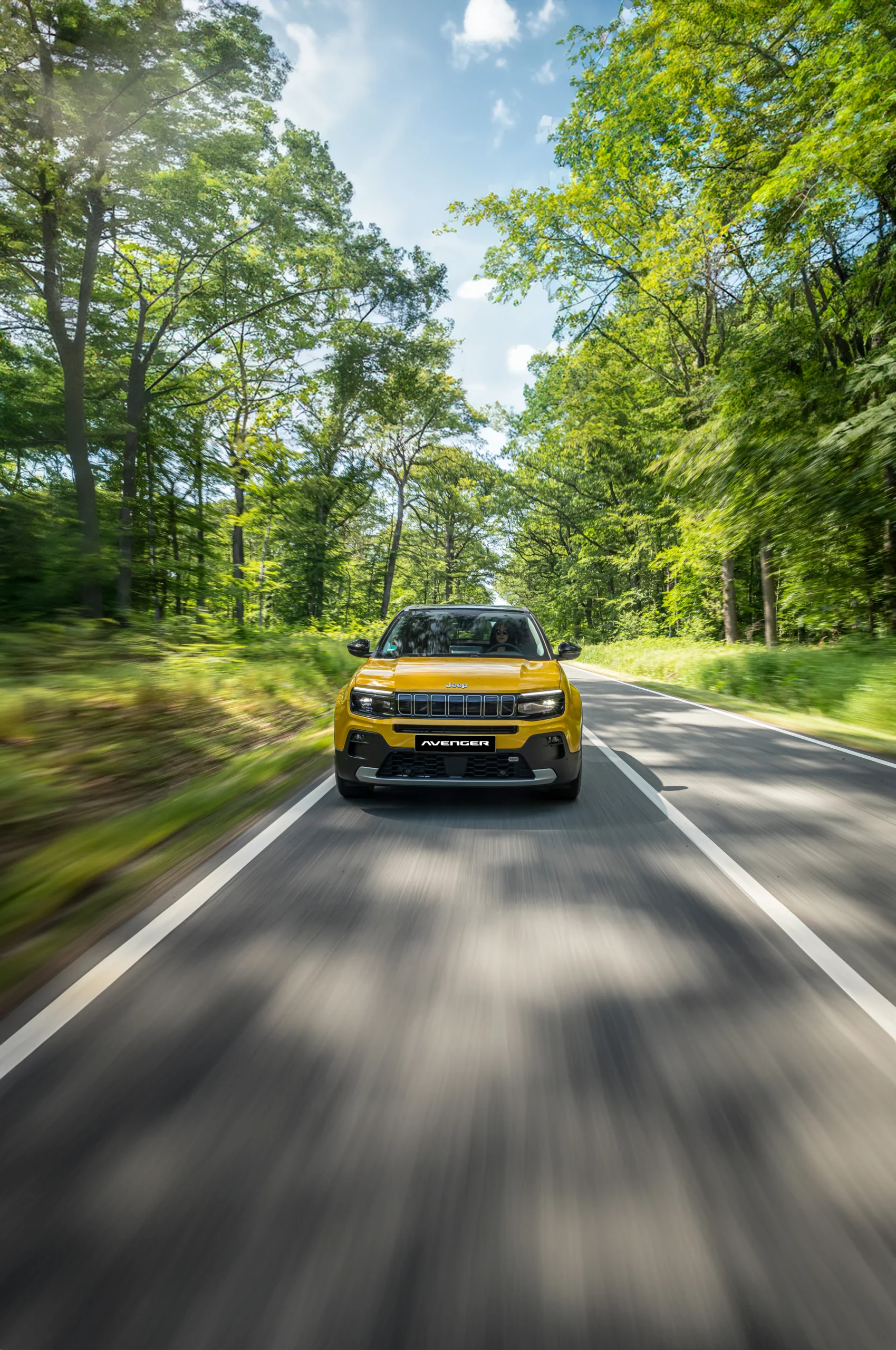 presencia de Fiat Jeep RAM: FIAT Avenger amarillo conduciendo en carretera boscosa