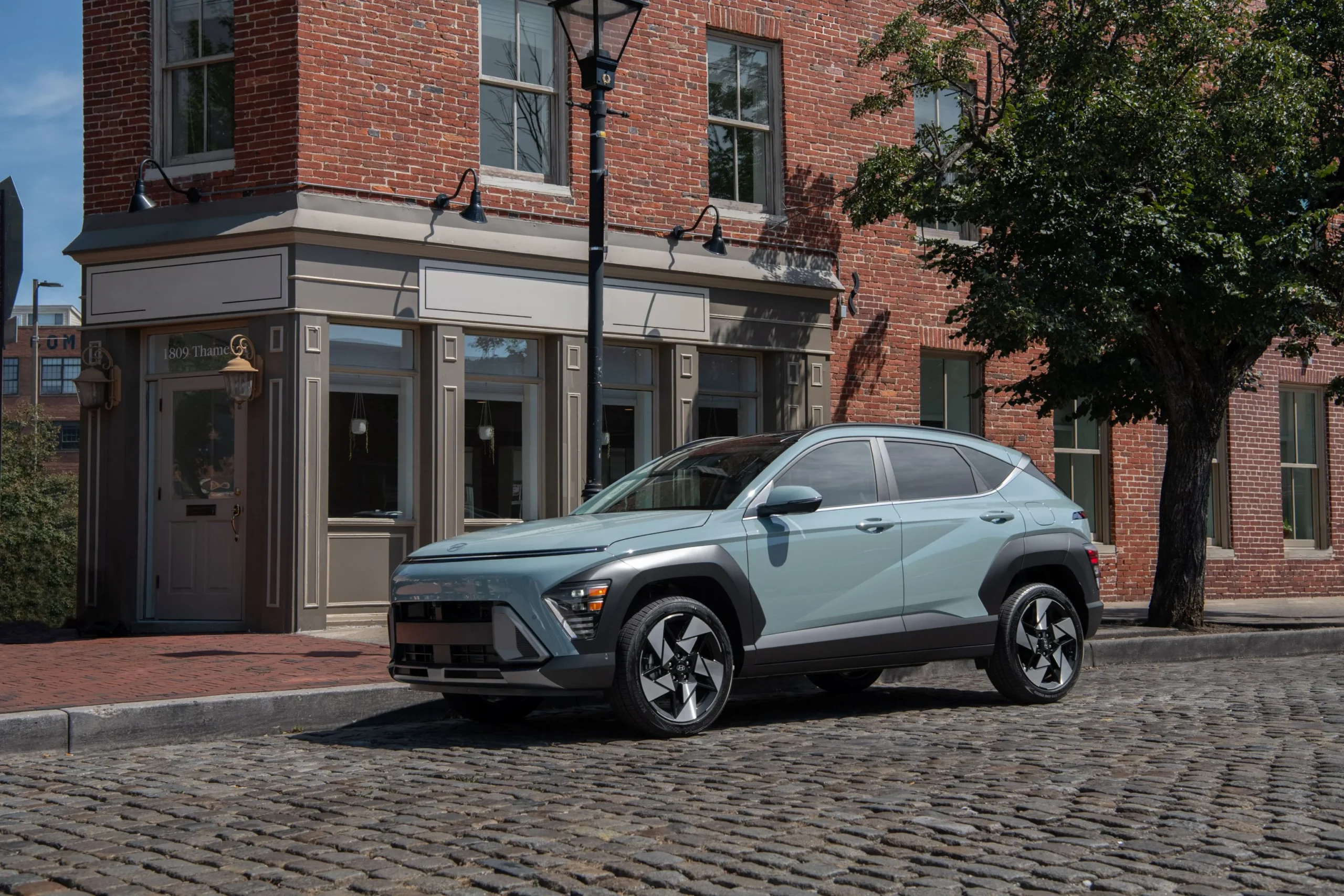 Hyundai Kona en la calle empedrada frente a edificio
