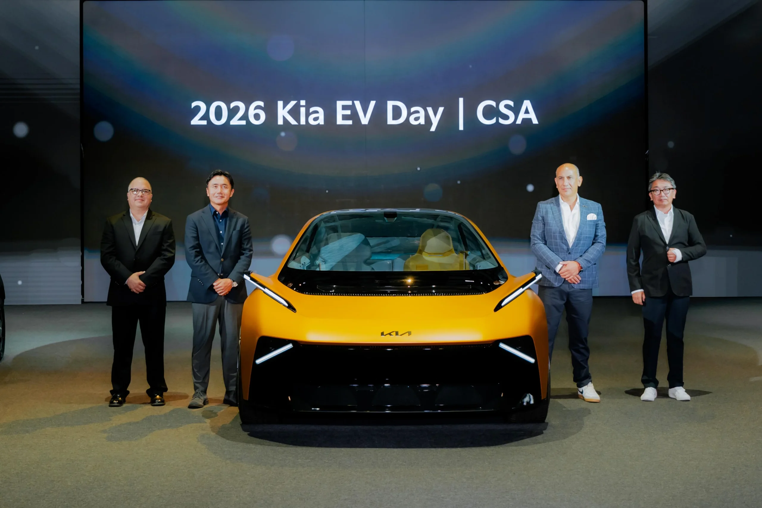 estrategia de electrificación de Kia: Directivos de Kia junto a nuevo vehículo eléctrico.
