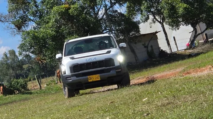 Kia Tasman pickup blanca con luces LED encendidas en demostración técnica.
