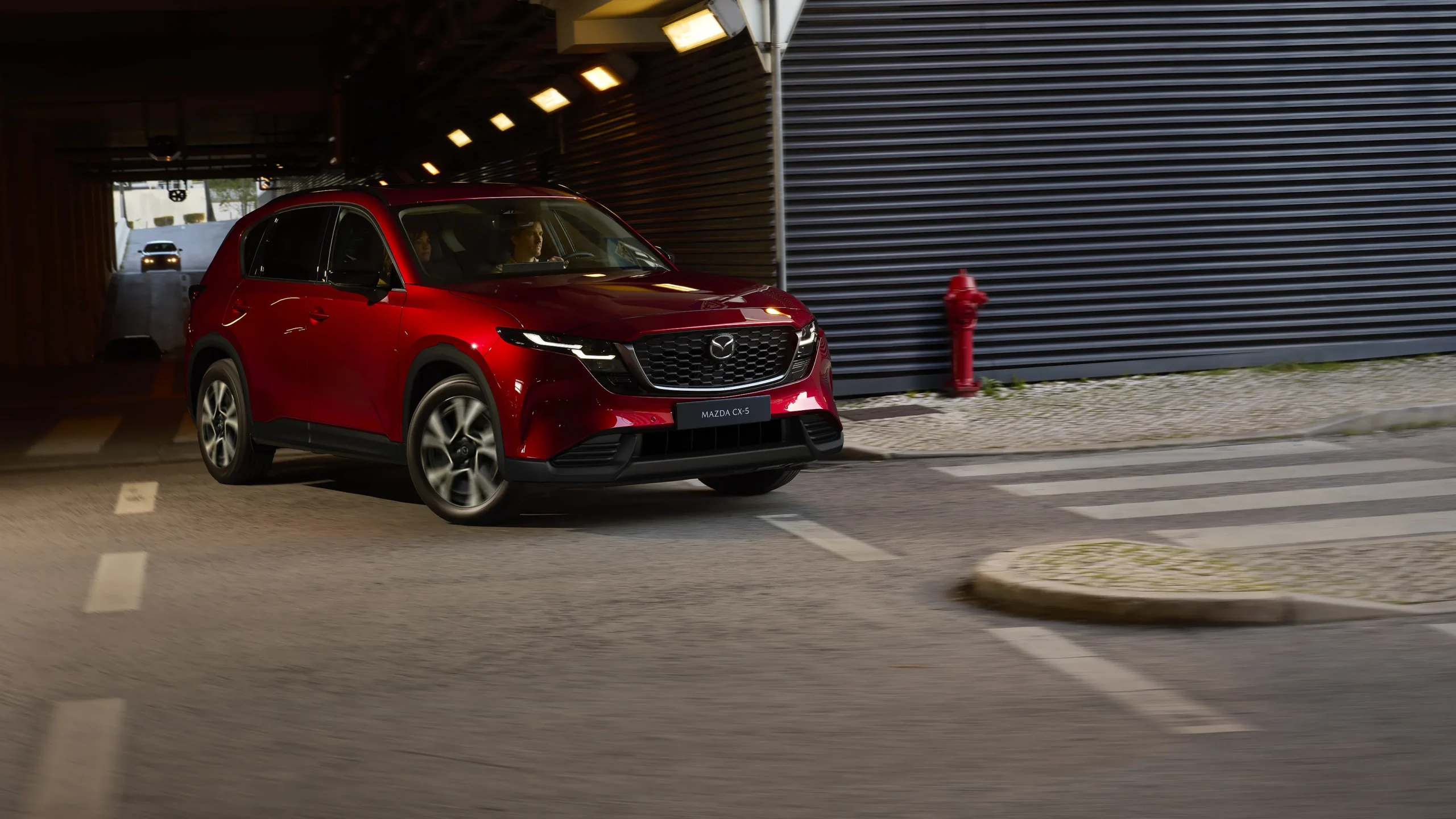Mazda CX-5 Híbrida roja en movimiento urbano.