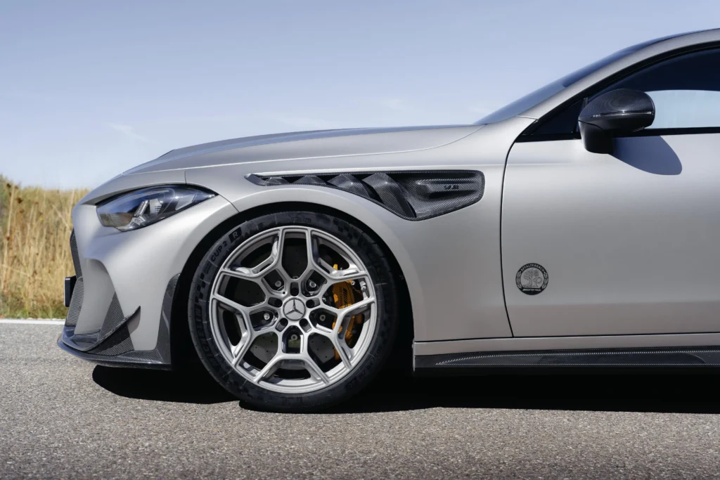 Mercedes-AMG CLE 646 Spezialanfertigung: Detalle frontal deportivo de vehículo Mercedes-AMG con rines.