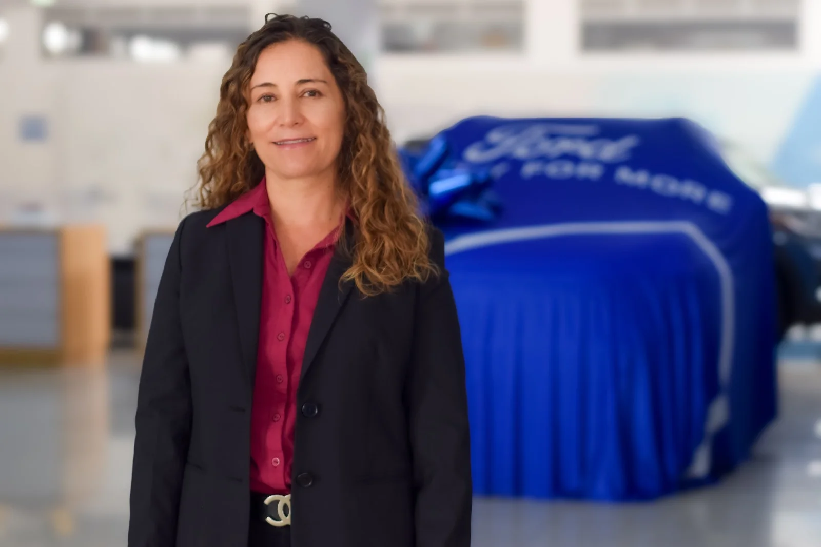 aniversario de Autonal: Directiva Observauto junto a vehículo Ford cubierto.