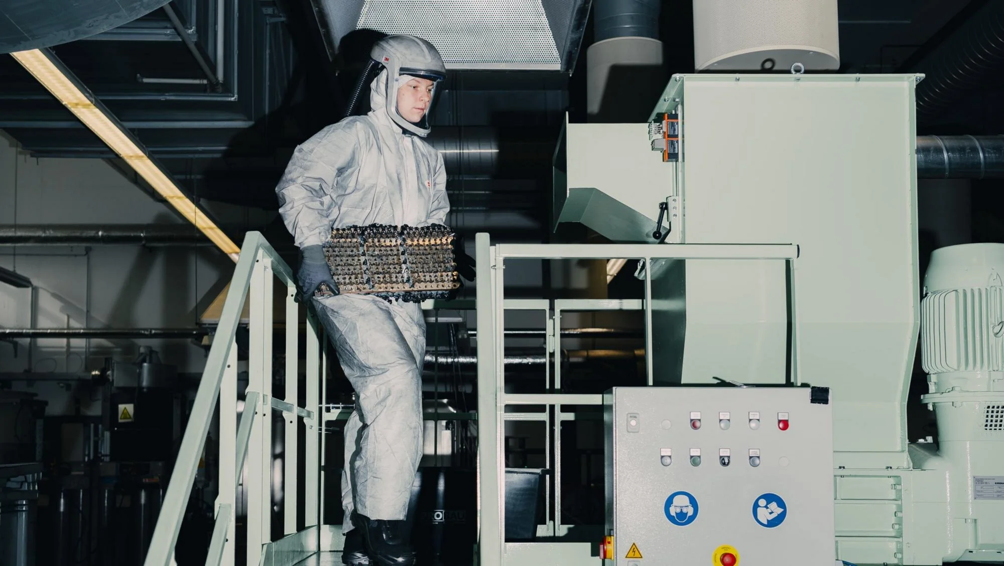 reciclaje de baterías de Porsche: Operario de Porsche manipulando baterías en fábrica.