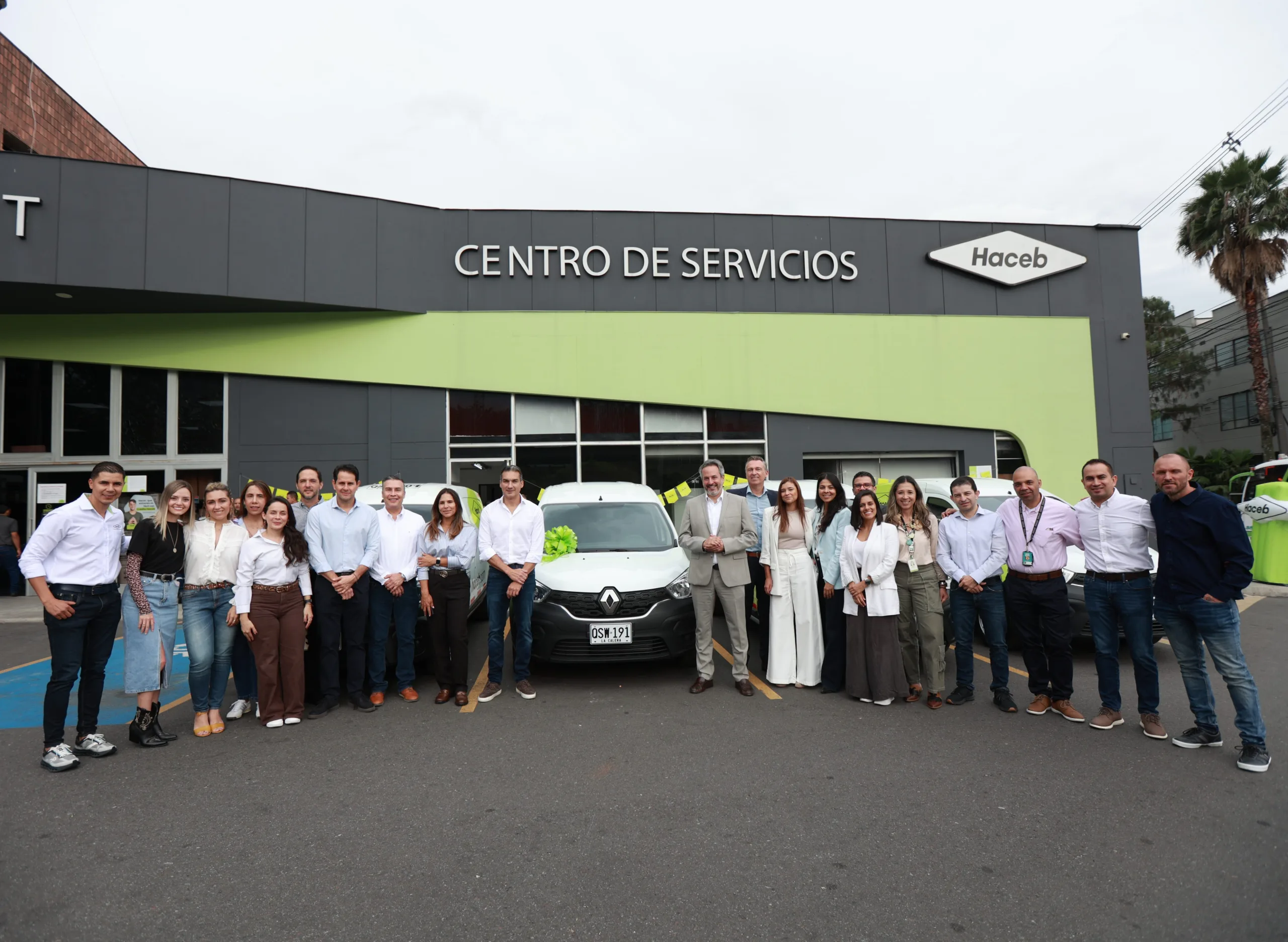 Renault Kangoo con grupo de personas frente a edificio