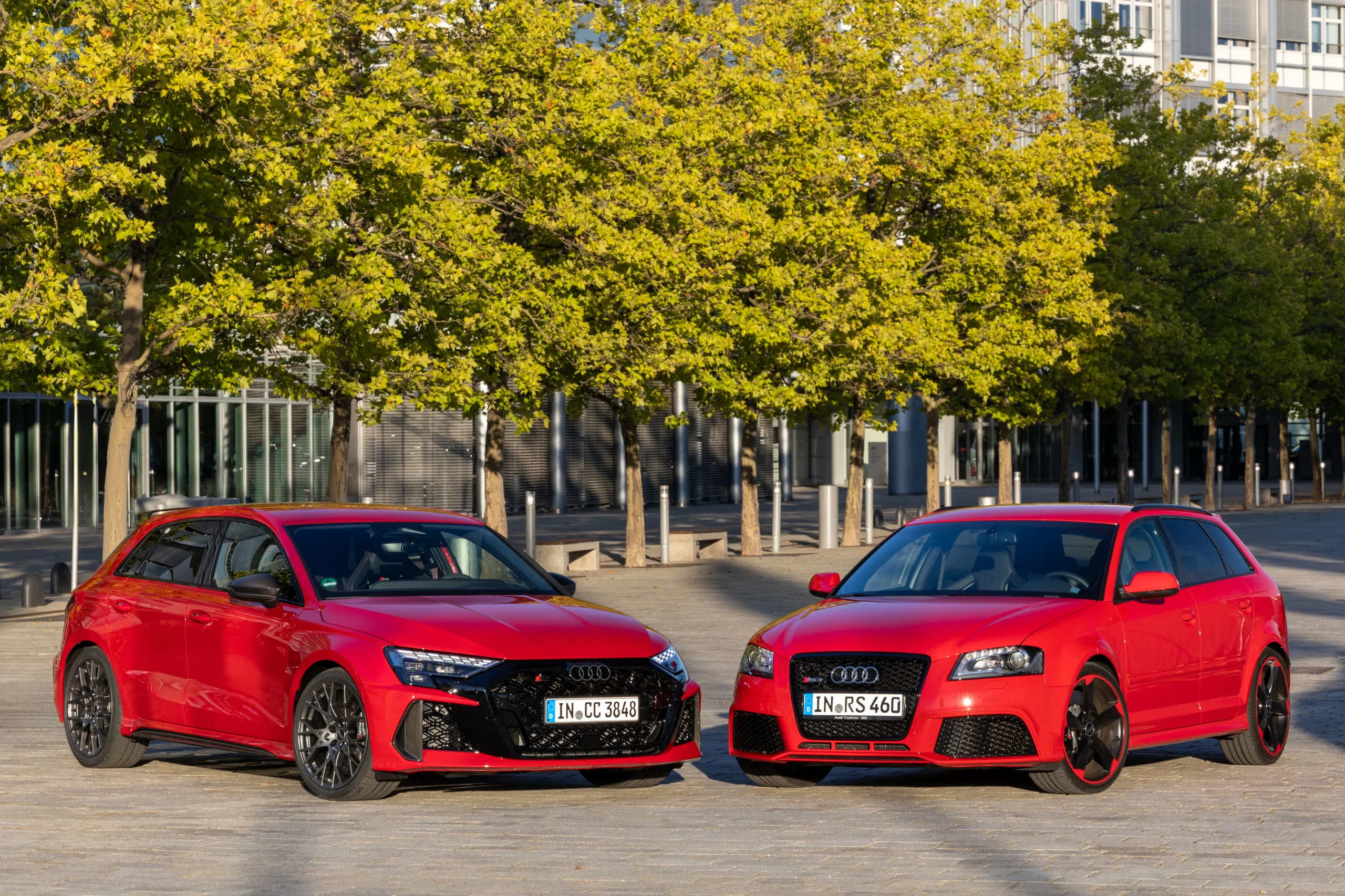 historia de Audi A3: Dos Audi RS3 Sportback rojos de perfil frontal.