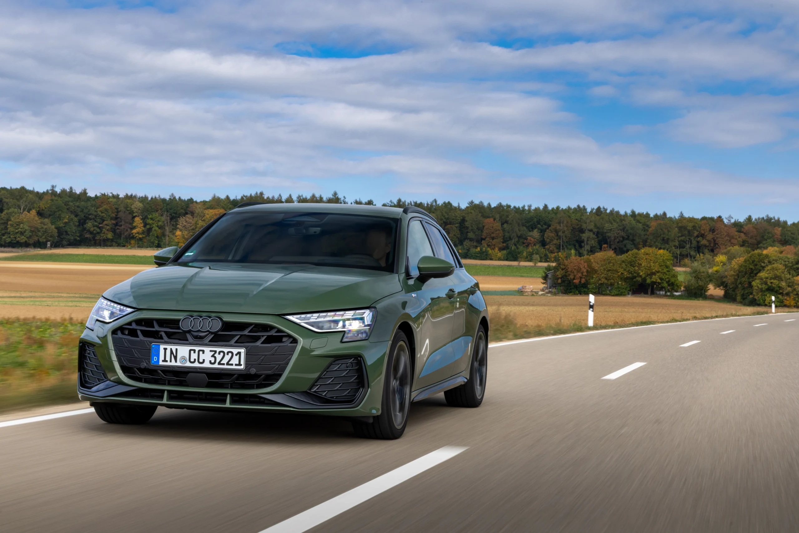 historia de Audi A3: Audi A3 Sportback verde en carretera con faros LED encendidos.