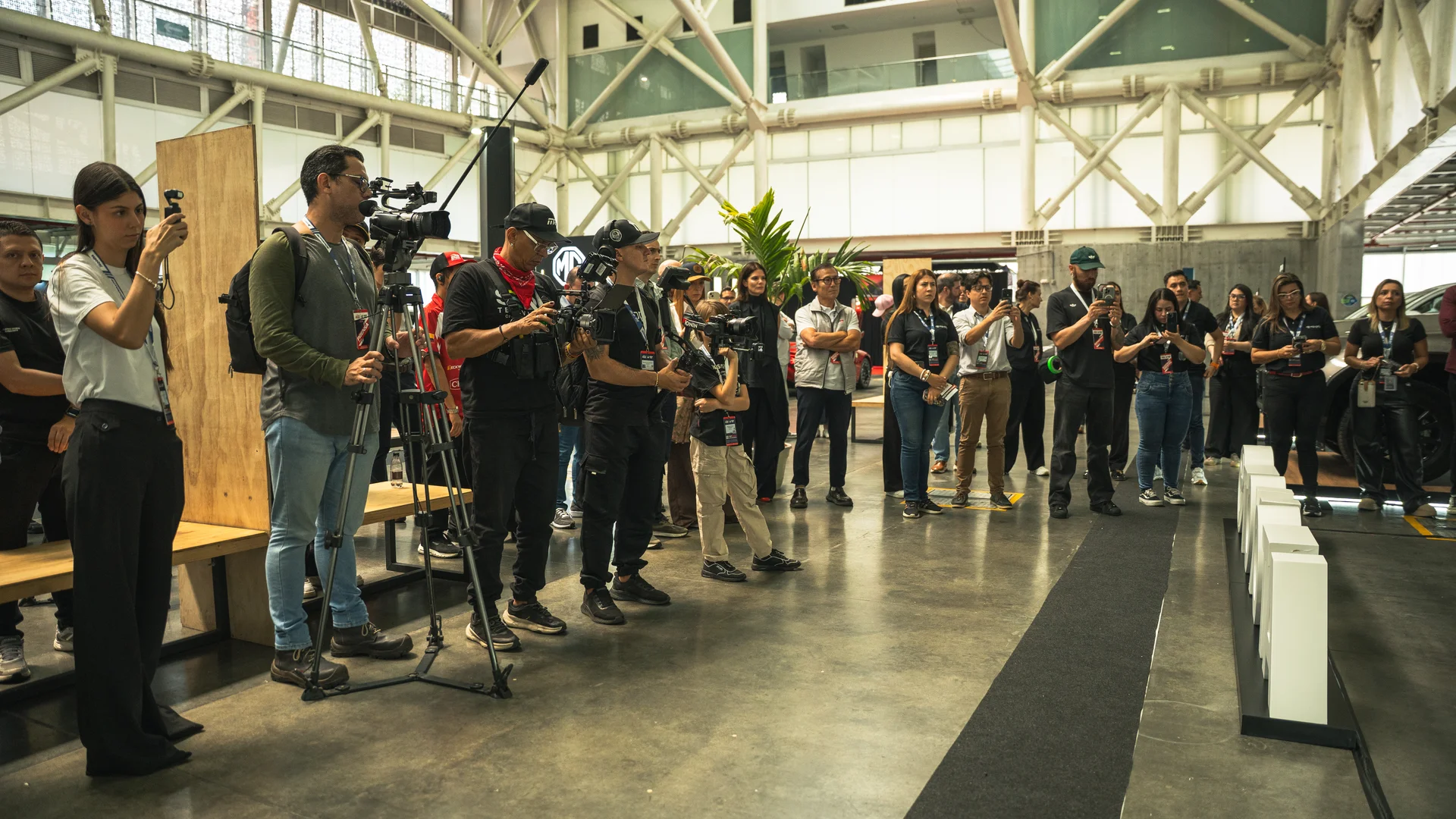 primer día de AutoShow Expocar 2026: Grupo de personas con cámaras en un evento automotriz.