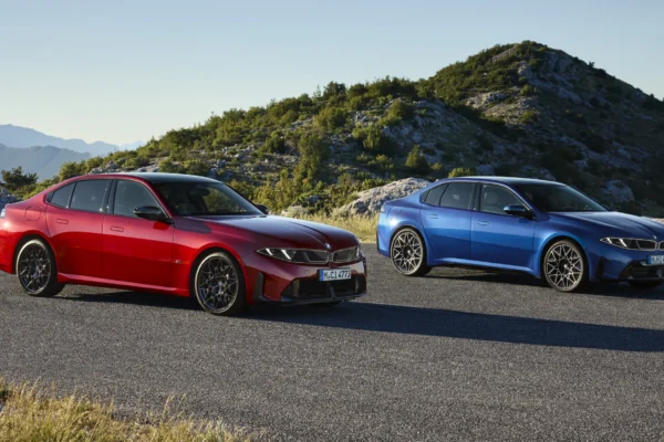 BMW Serie 3: BMW i4 M50 rojos y azules en carretera montañosa.