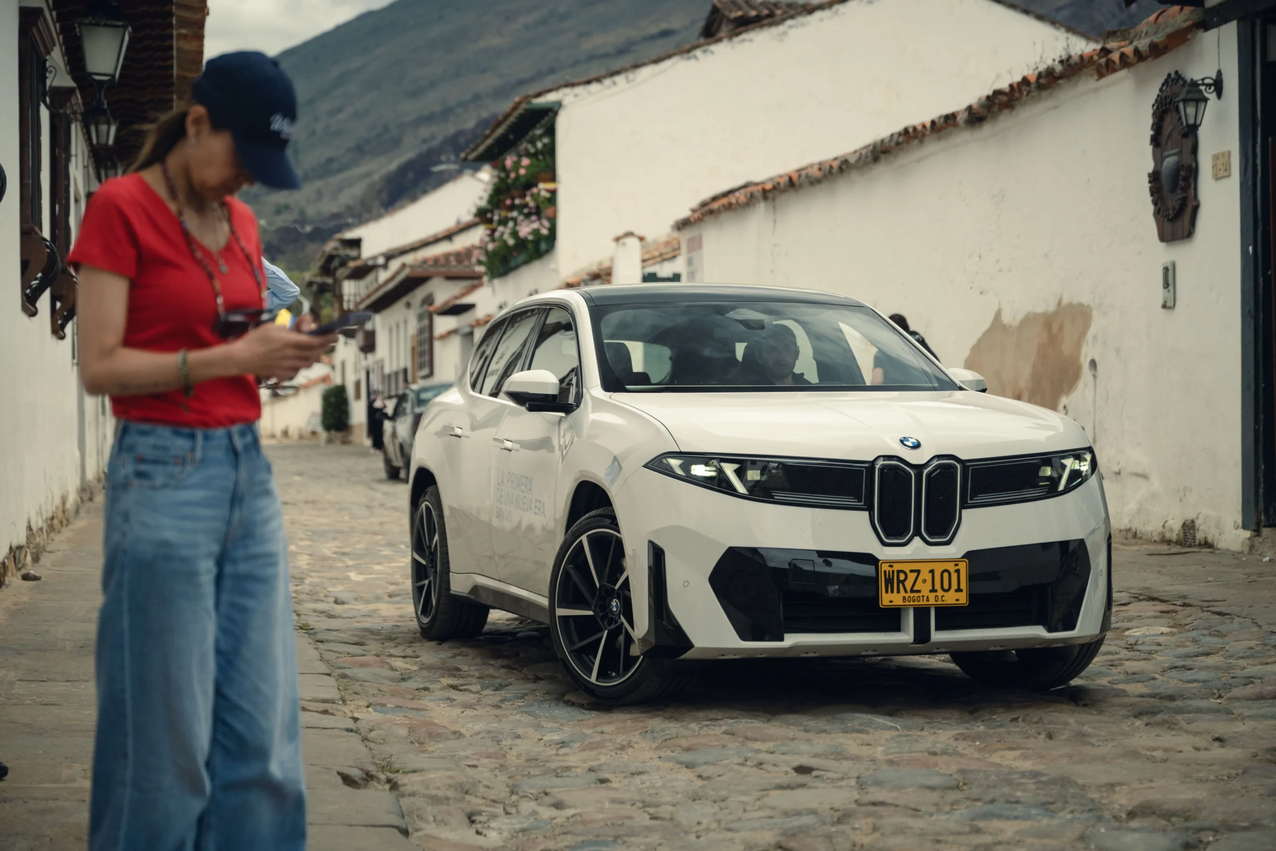 BMW iX3 blanco en Villa de Leyva con persona.