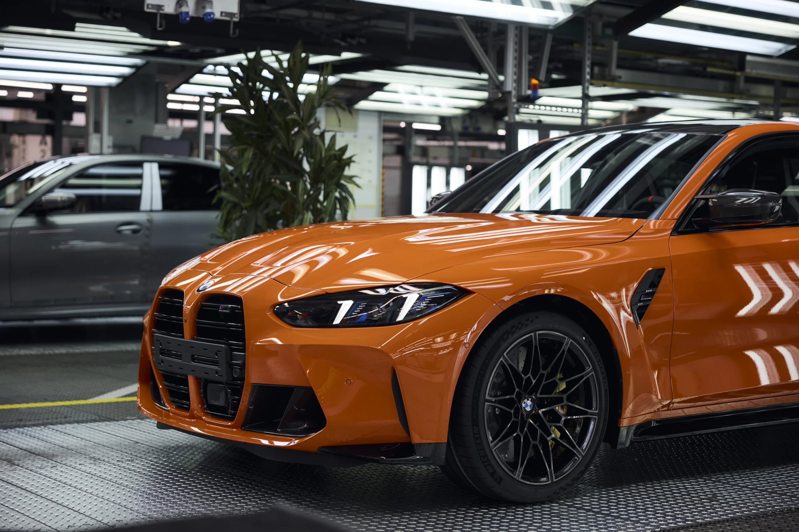 Frente de BMW M3 naranja en línea de producción.