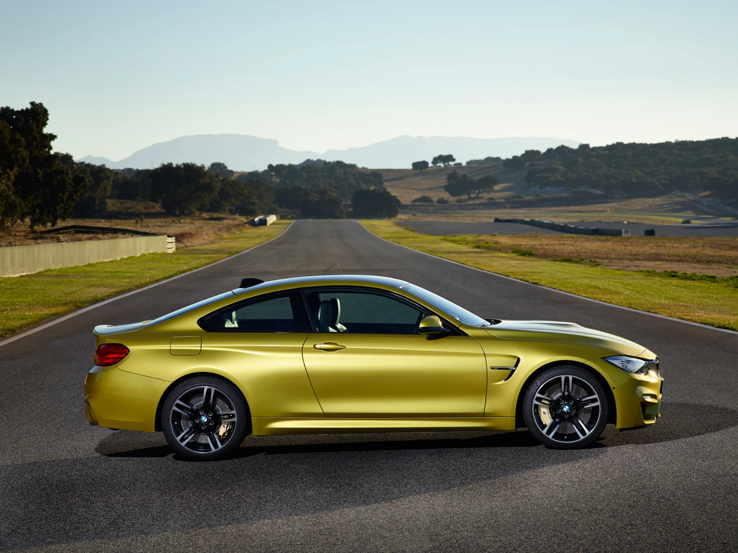 BMW M3: Un legado de 40 años forjando la excelencia en deportivos de alta gama 5 BMW M3: BMW M4 Coupé amarillo lateral pista