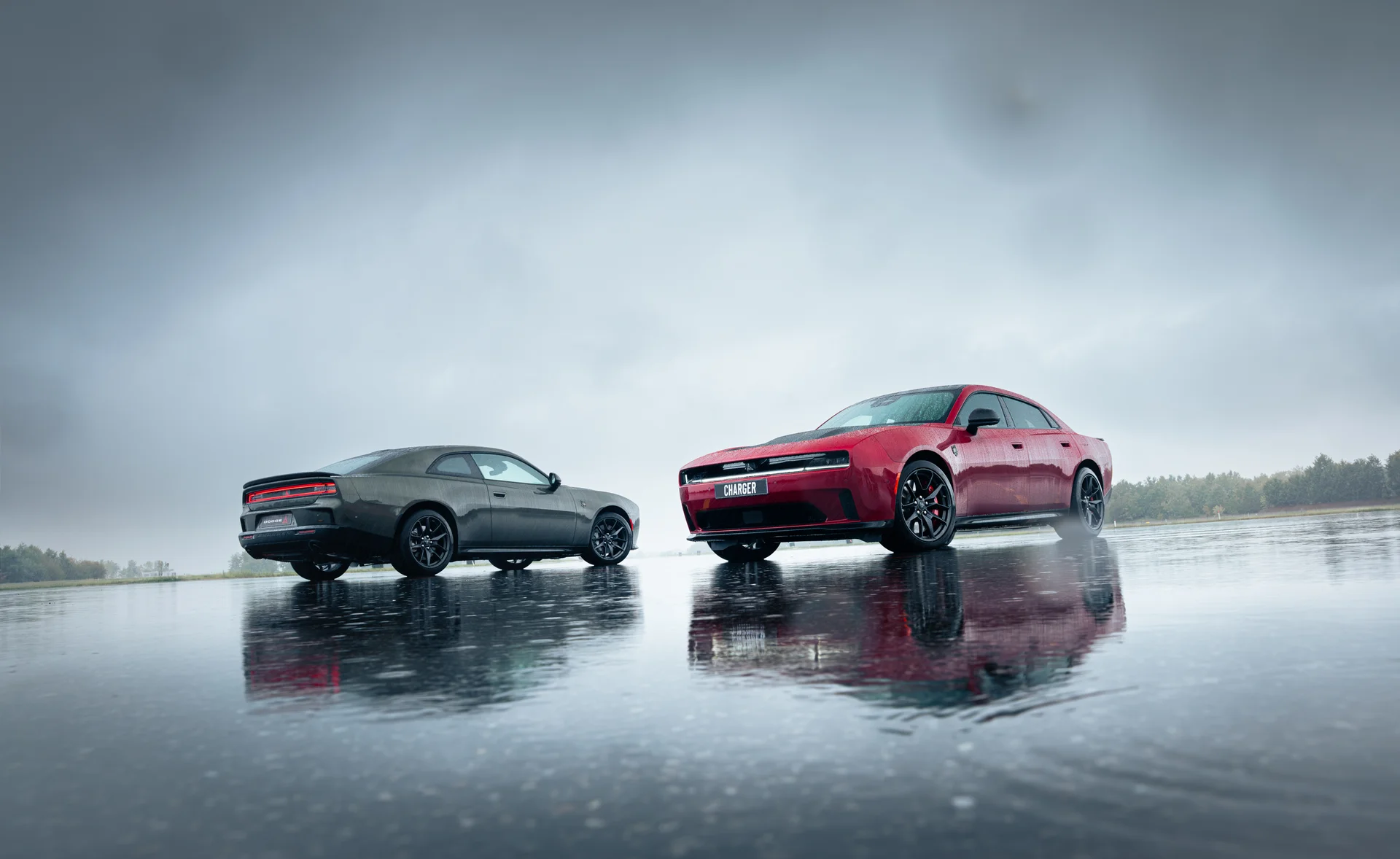 Dos Dodge Charger, coupé y sedán en pista mojada.