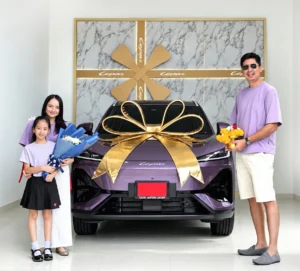 LEPAS Global Elegant Lifestyle Week: Familia con vehículo nuevo adornado con gran lazo dorado.