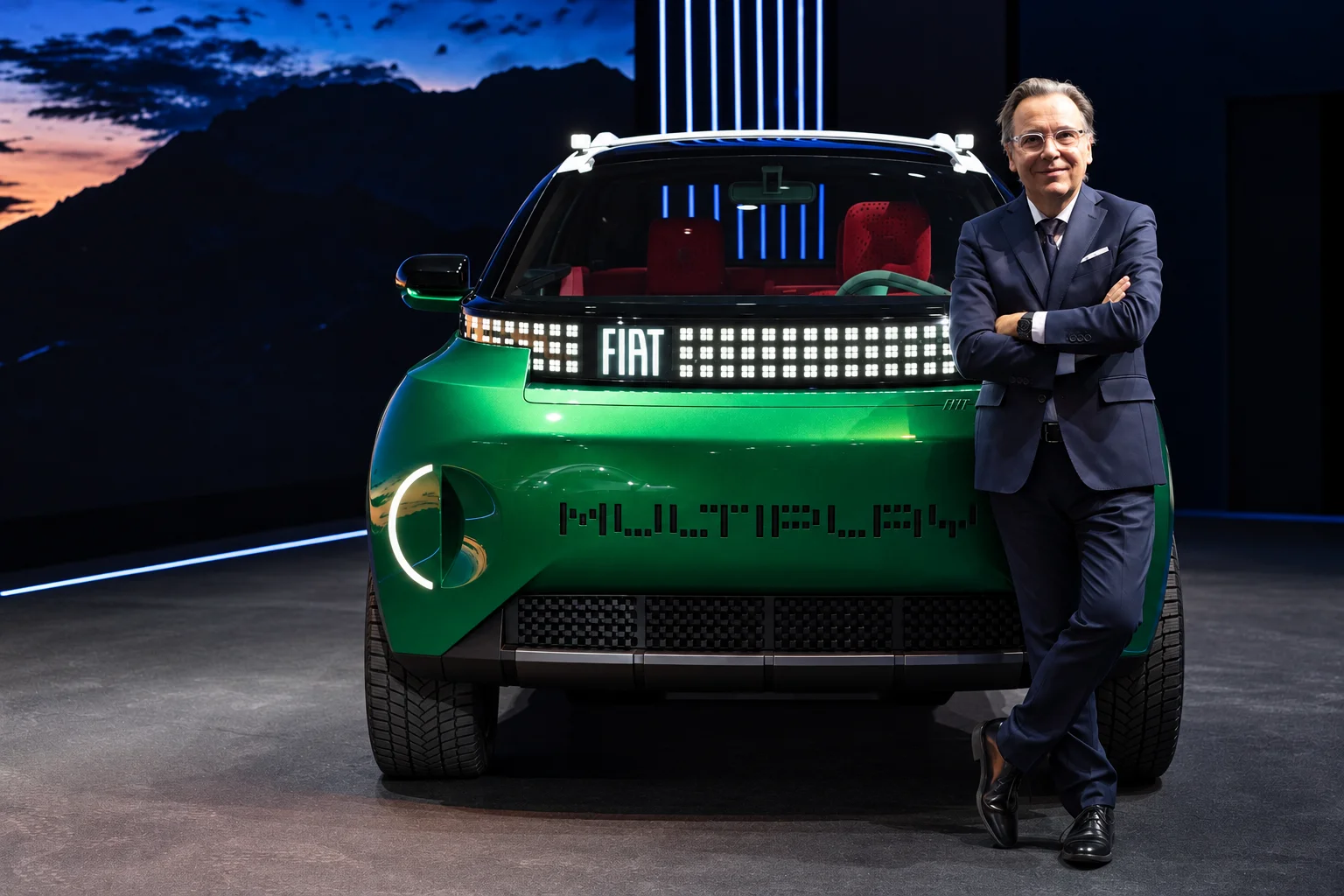 Hombre posa junto al FIAT Multiplay verde.