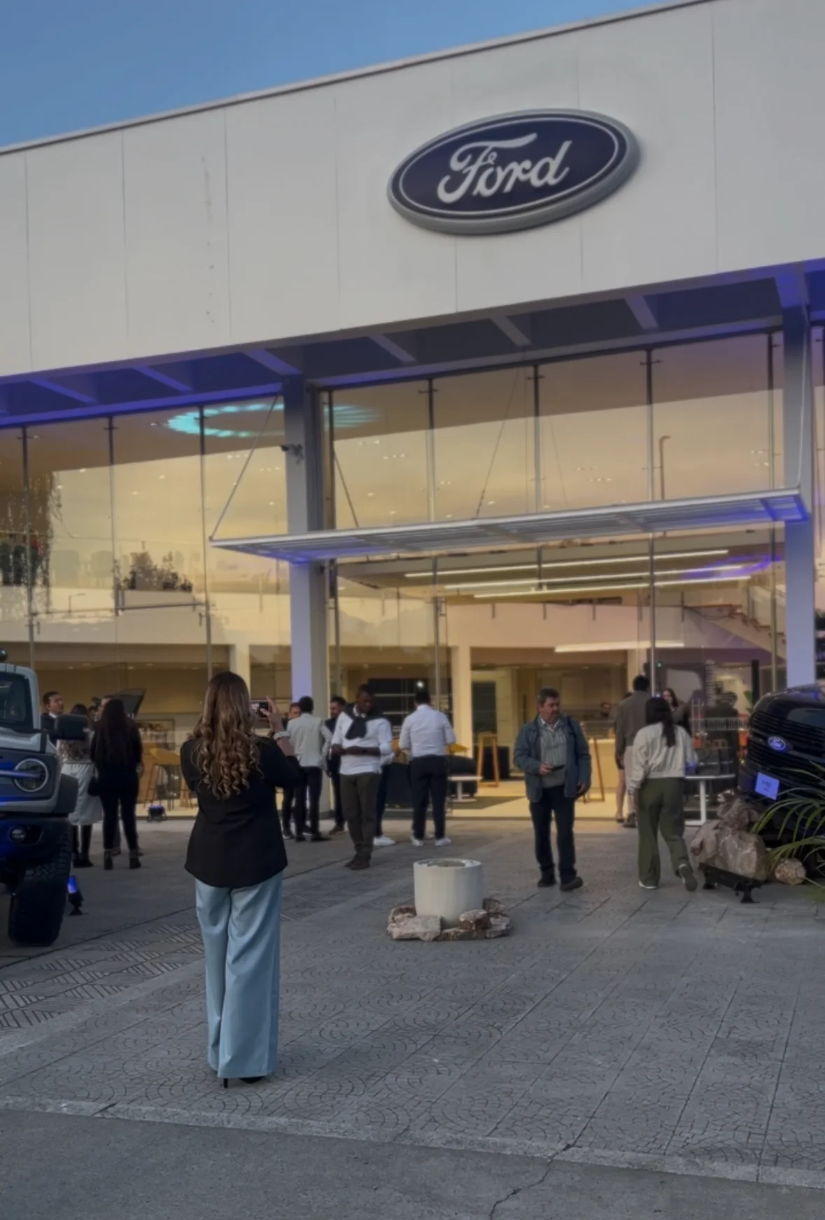 expansión de Ford: Fachada de concesionario Ford con personas en el exterior.