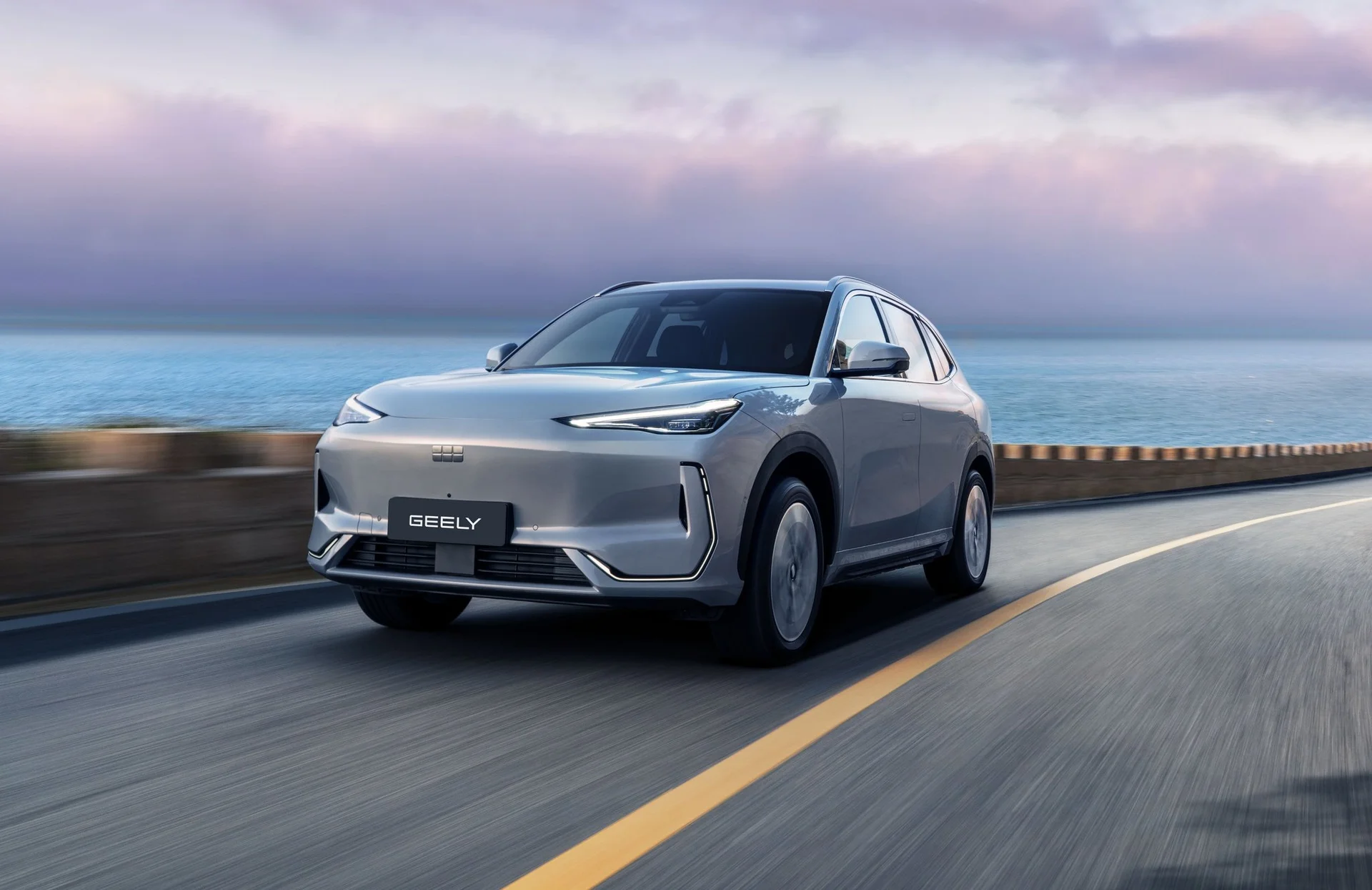 integración de Google en Geely: Geely SUV plateado en carretera costera, integración Google.