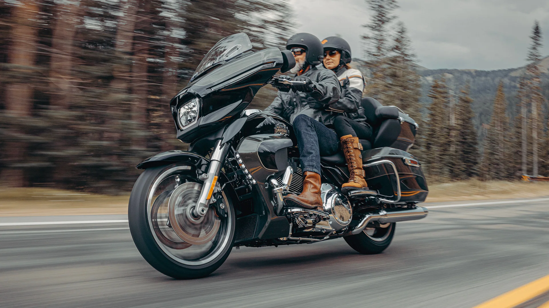 Expo2Ruedas 2026: Pareja en motocicleta Harley-Davidson recorriendo ruta escénica.