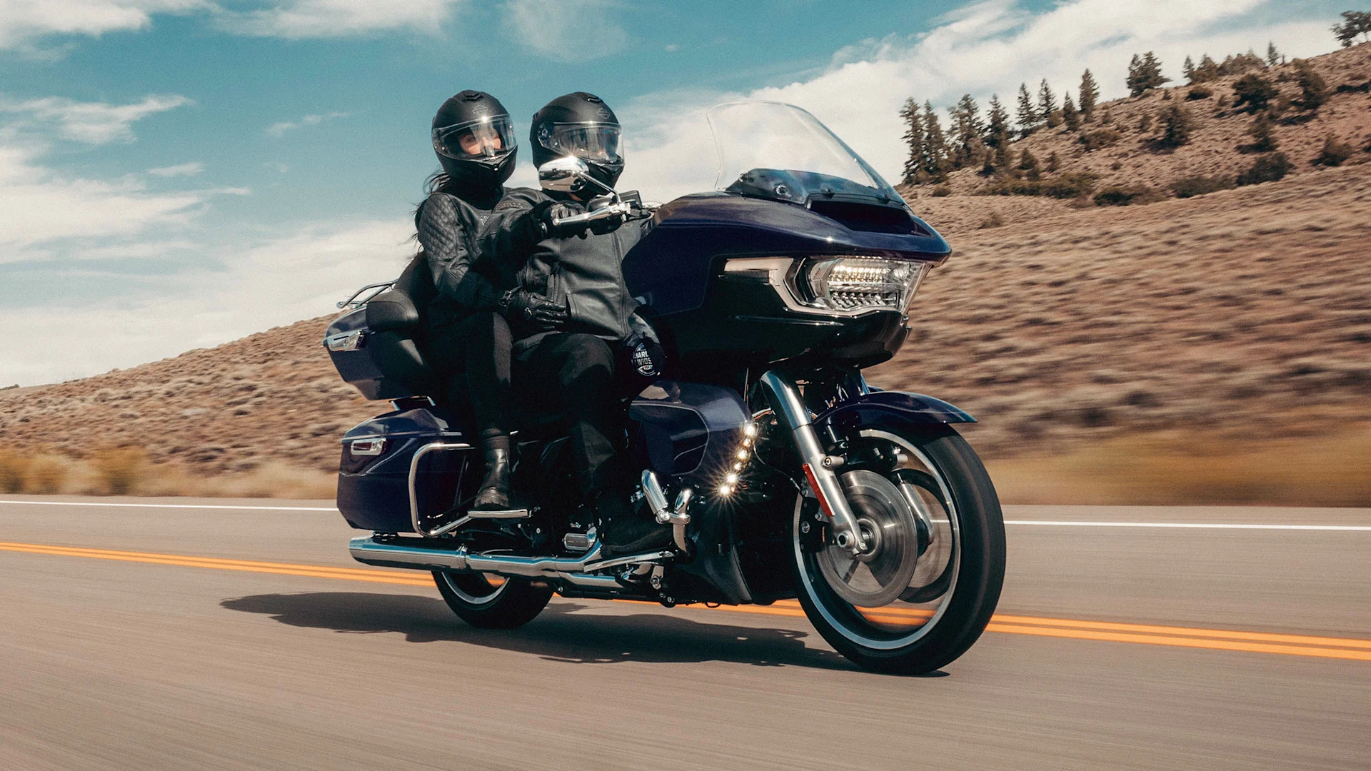 Expo2Ruedas 2026: Motocicleta Harley-Davidson Road Glide en carretera con dos ocupantes.