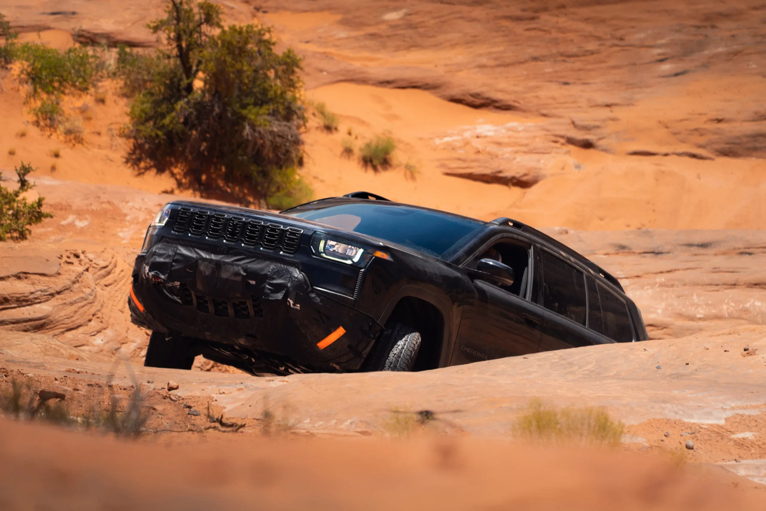 Jeep Cherokee Trailhawk: Jeep Cherokee en acción todoterreno en terreno rocoso.
