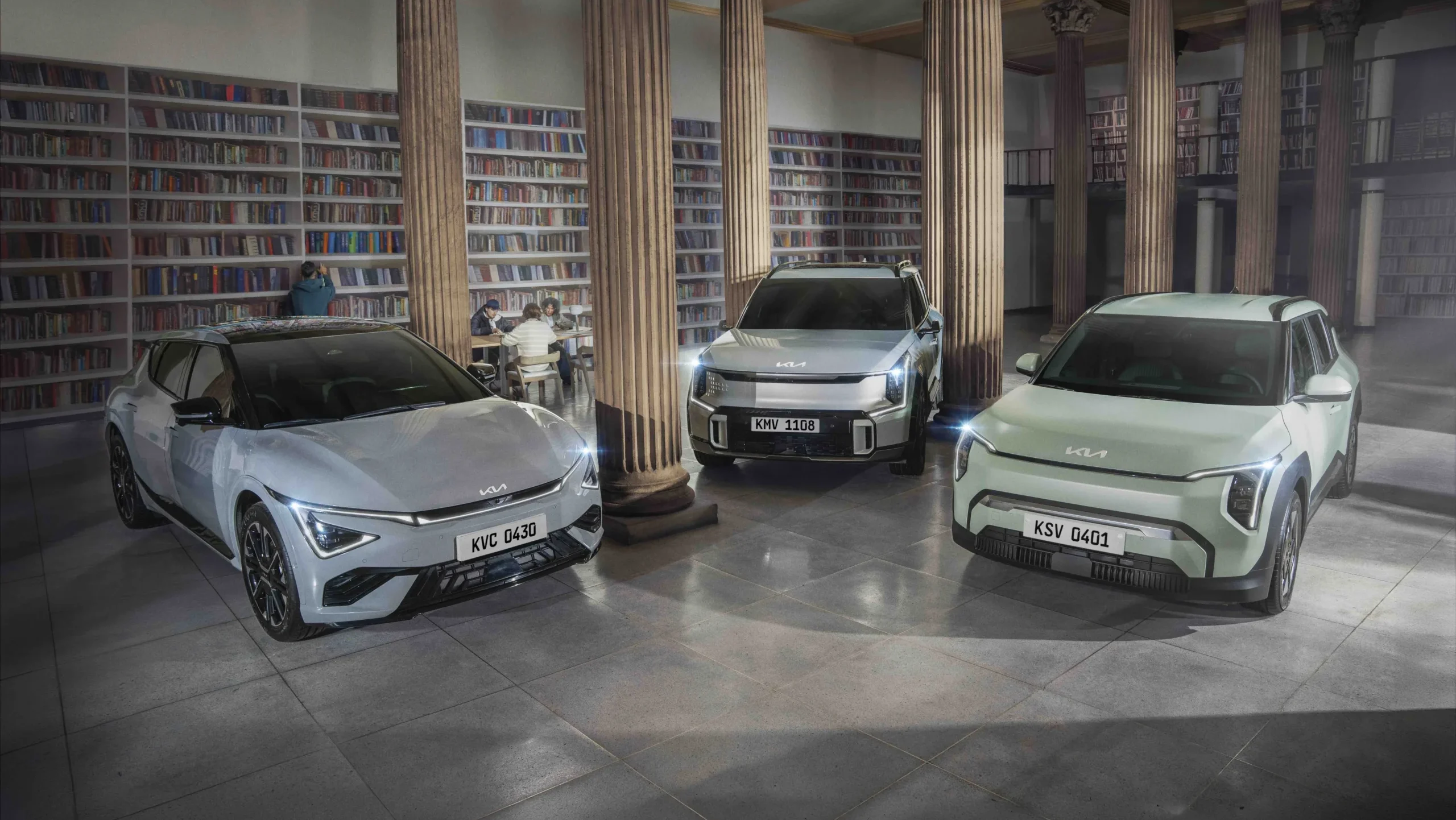 Kia EV3, EV5 en biblioteca, personas estudiando.