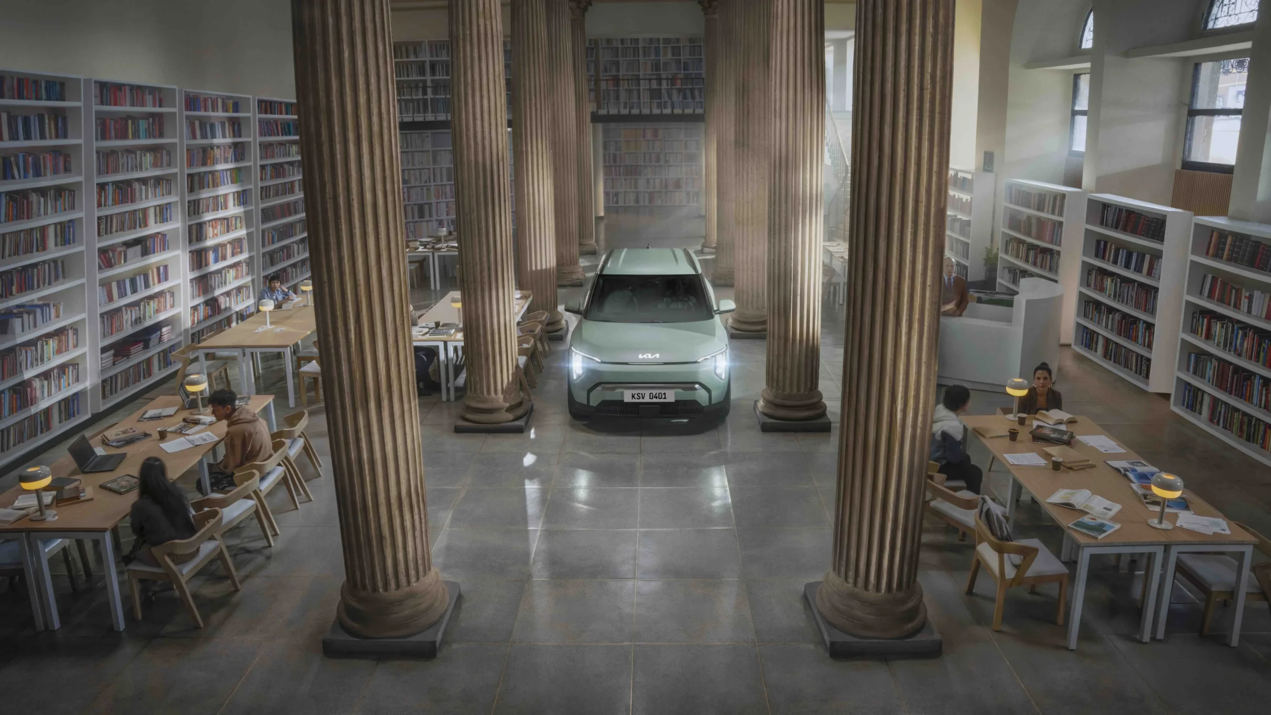 Kia EV3 en biblioteca con personas estudiando.