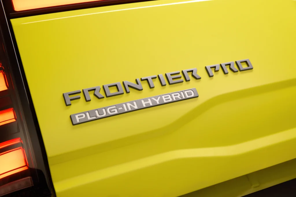 Nissan Frontier PRO PHEV: Emblema Frontier PRO Plug-In Hybrid en pickup Nissan amarilla.