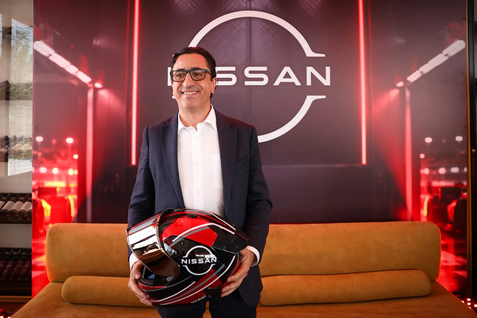 cambios en dirección Nissan: Ricardo Toro con casco Nissan y logo de marca al fondo.