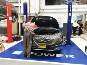 posventa de Nissan: Técnico de Nissan trabajando en motor de carro.