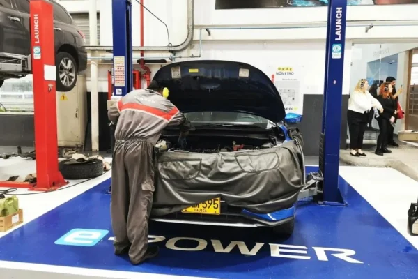 posventa de Nissan: Técnico de Nissan trabajando en motor de carro.