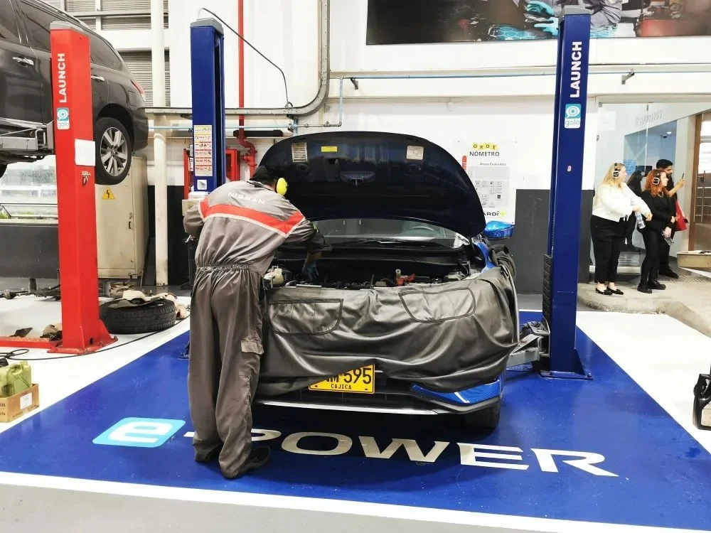 posventa de Nissan: Técnico de Nissan trabajando en motor de carro.
