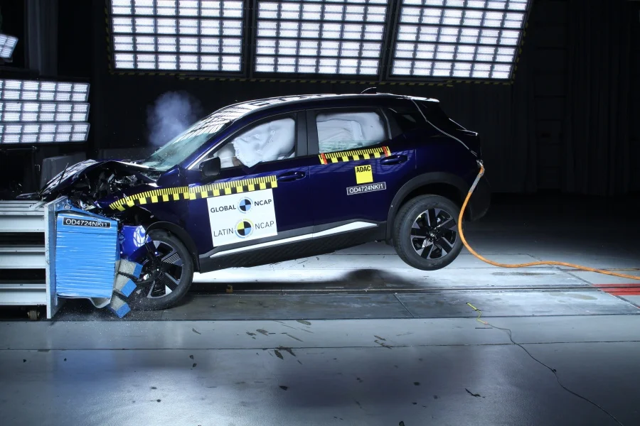 Nissan Kicks: Vehículo azul en prueba de choque, airbags desplegados.