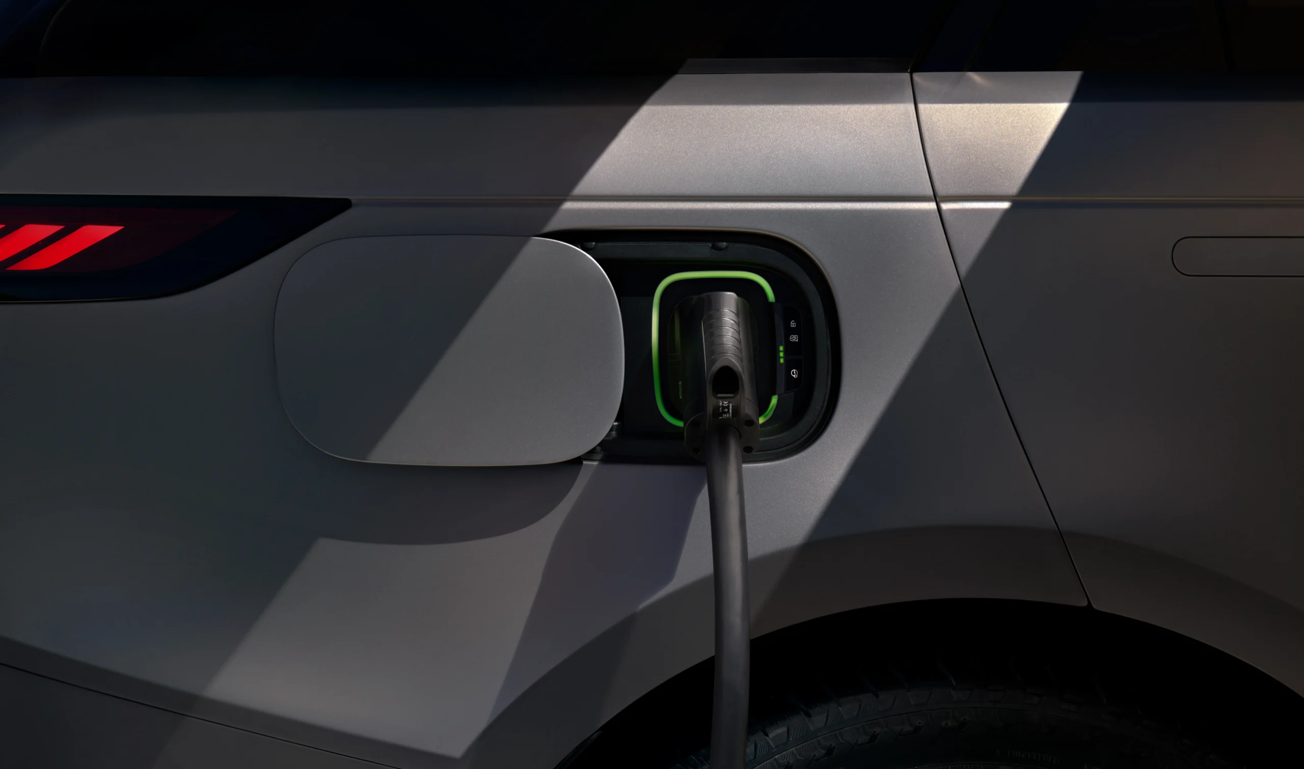 Range Rover Sport Electric: potencia y agilidad en un SUV de lujo electrificado 5 Range Rover Sport Electric: Puerto de carga de vehículo eléctrico con enchufe conectado.