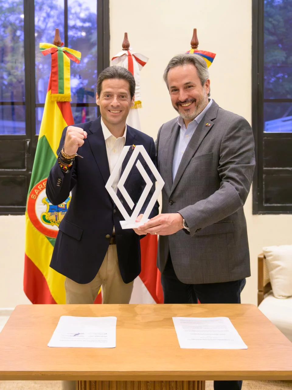 proyecto industrial Renault: Dos directivos sonríen, firman pacto industrial Renault.