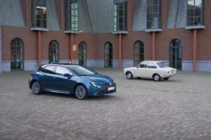 Dos generaciones del Toyota Corolla frente a un edificio histórico.