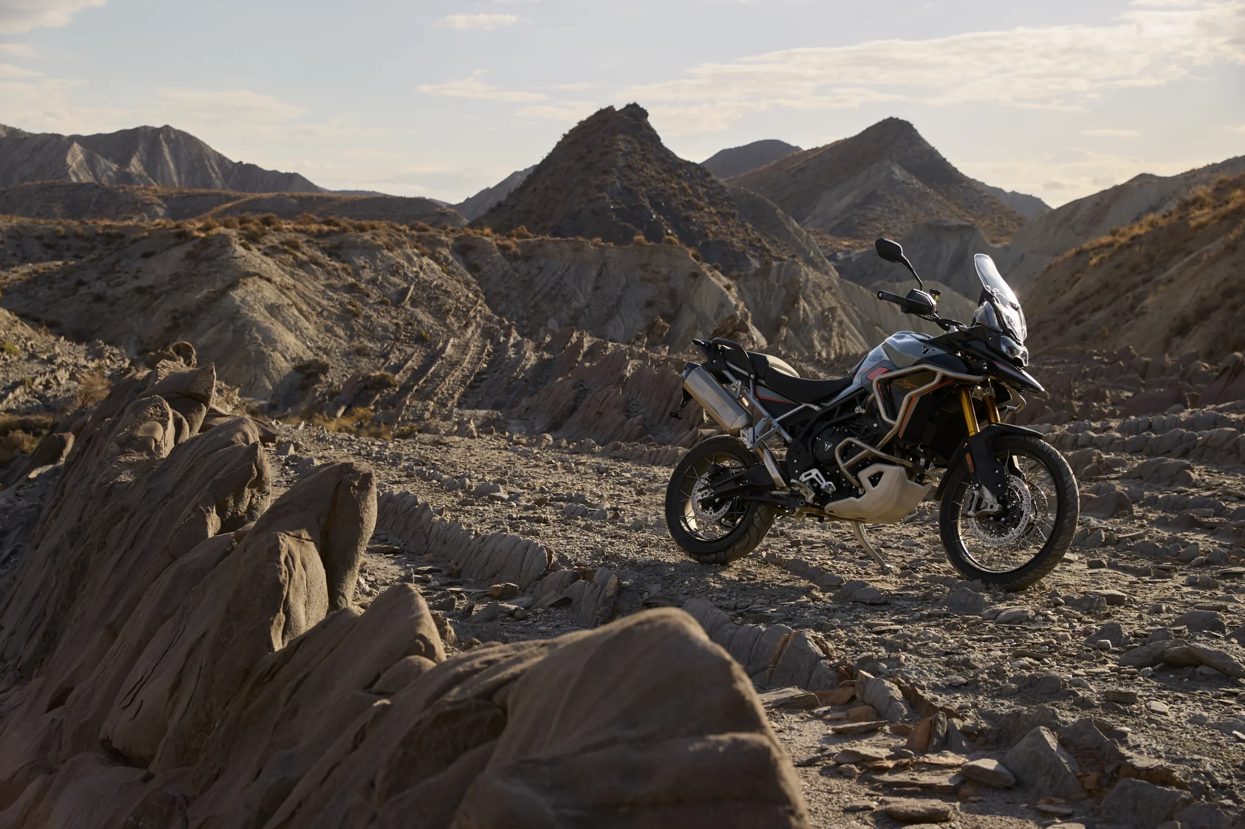 Triumph Tiger 900 Desert Edition en paisaje rocoso.