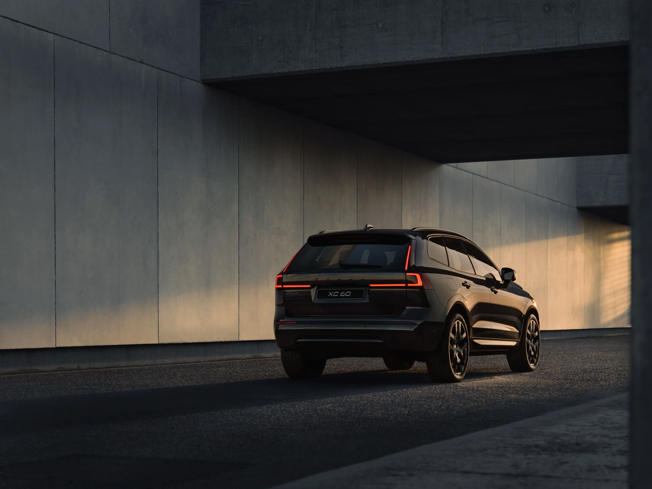 Volvo XC60 y XC90 híbridos: la autonomía extendida revoluciona la experiencia SUV 4 Volvo XC60 y XC90 híbridos: Vista trasera del Volvo XC60 negro con luces LED encendidas.