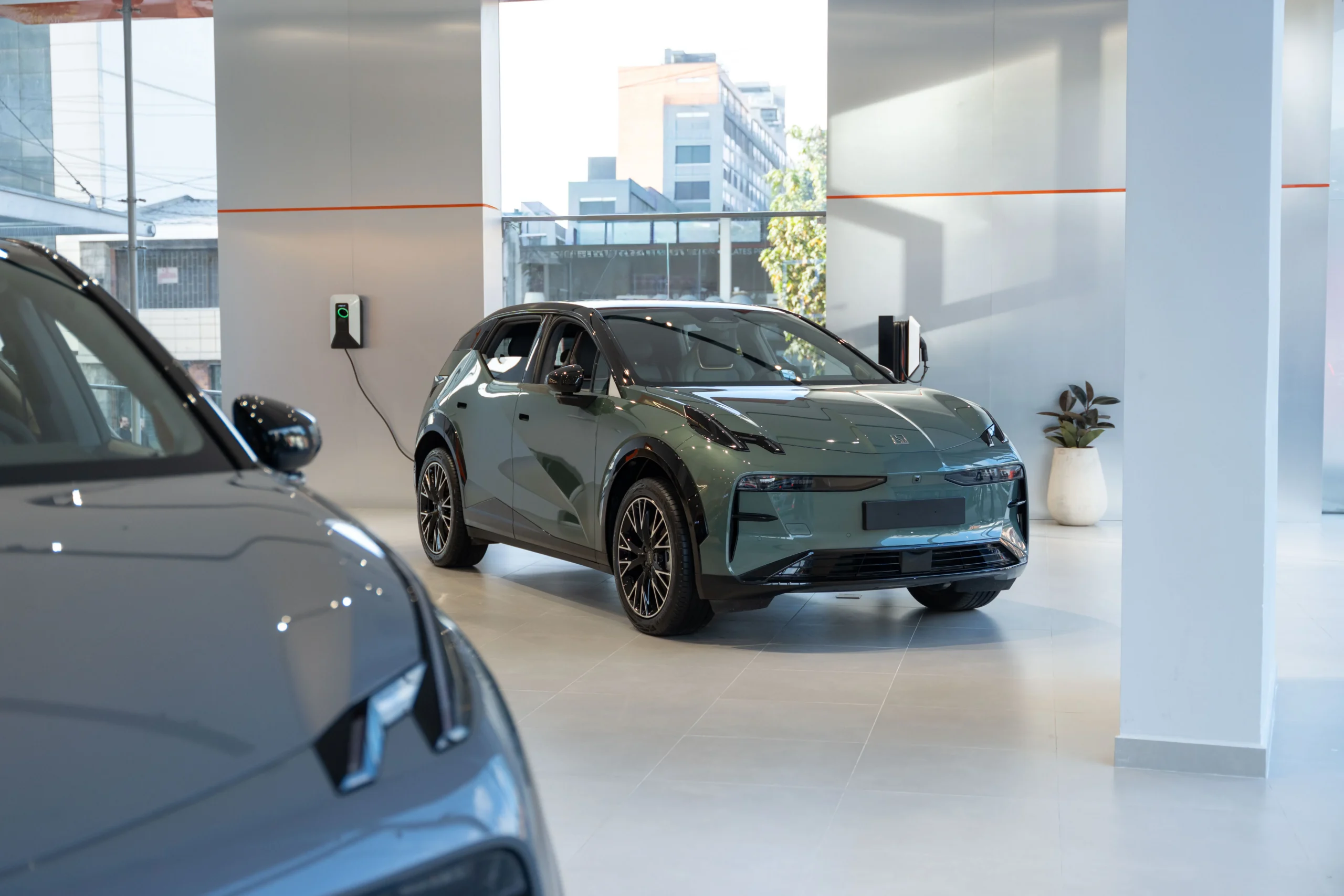 ventas de Zeekr: Zeekr SUV eléctrico verde con cargador en concesionario.